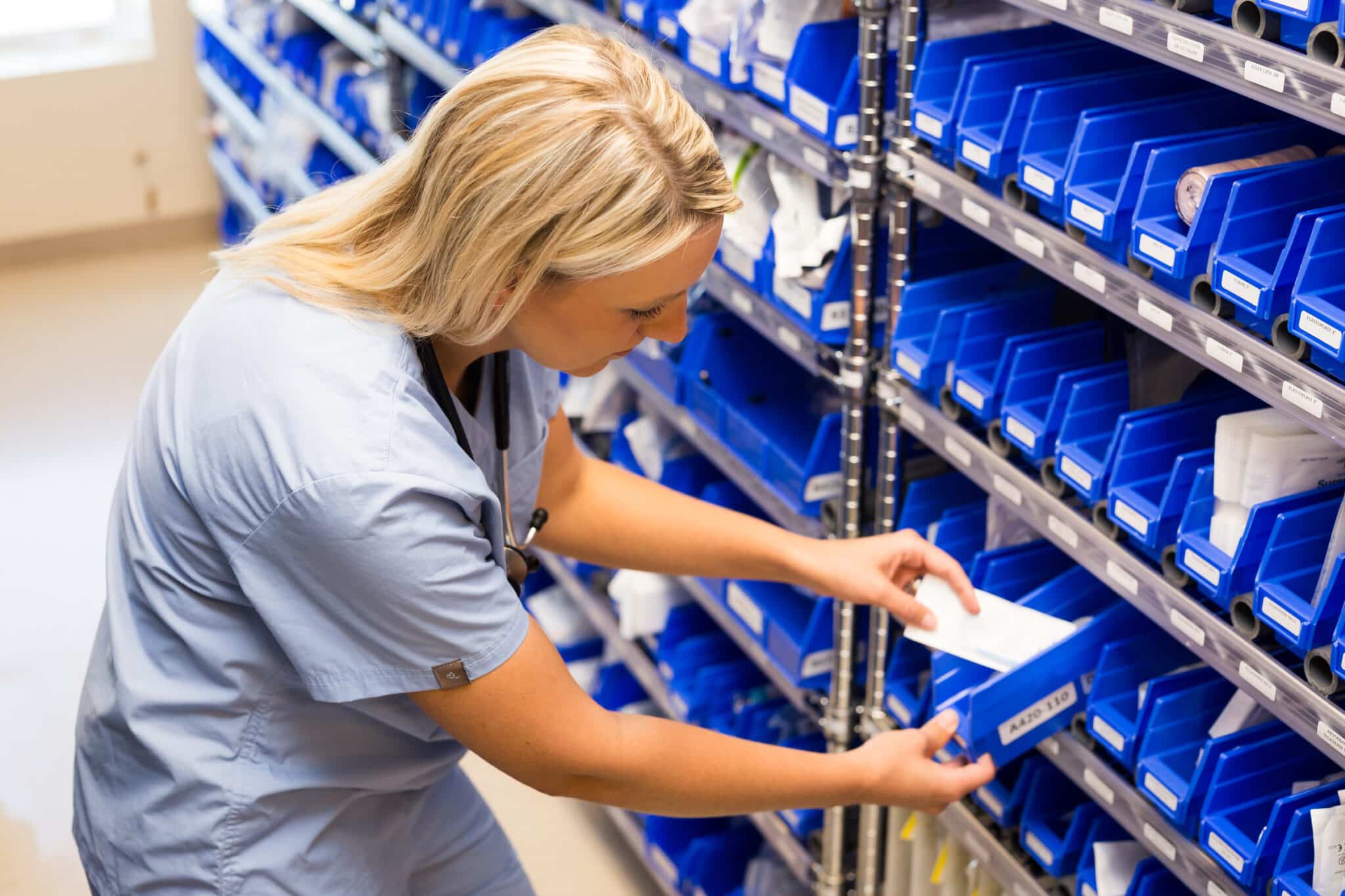 nurse grabbing supplies from BlueBin Kanban bin